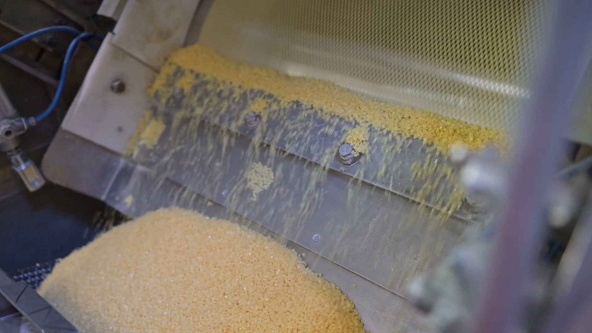 Goldgelbe Spezialwachs-Granulate fallen aus der Voelpker Produktionsanlage